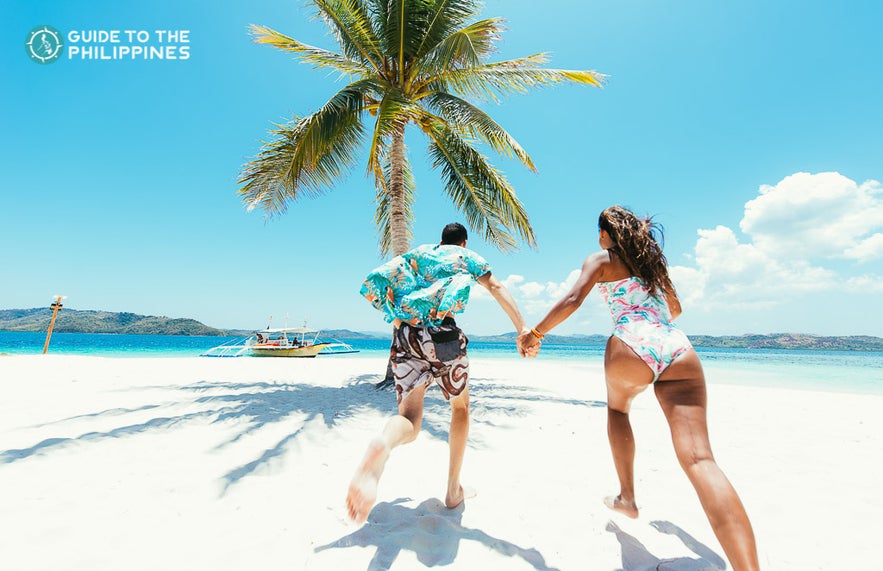 Couple at a white sand beach in Coron, Palawan, Philippines Couple at a white sand beach in Coron, Palawan, Philippines