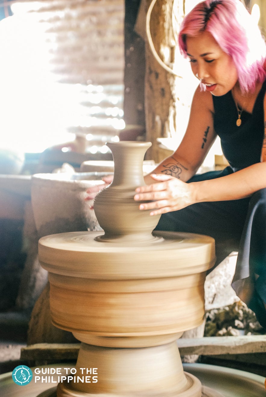 Female traveler learning the basics of pottery making at RG Jar Factory in Vigan Female traveler learning the basics of pottery making at RG Jar Factory in Vigan