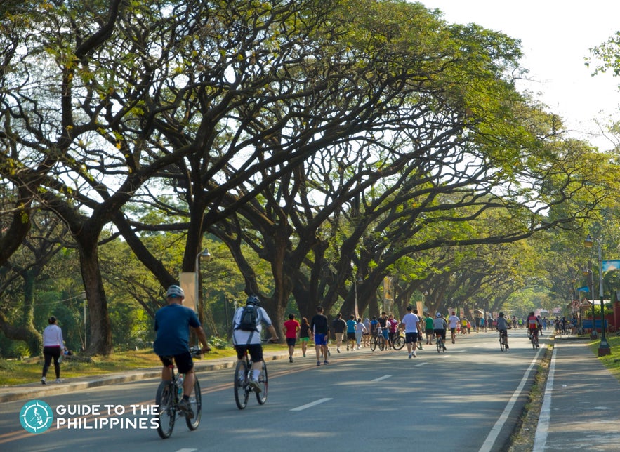 People cycling in the Academic Oval of UP Diliman People cycling in the Academic Oval of UP Diliman