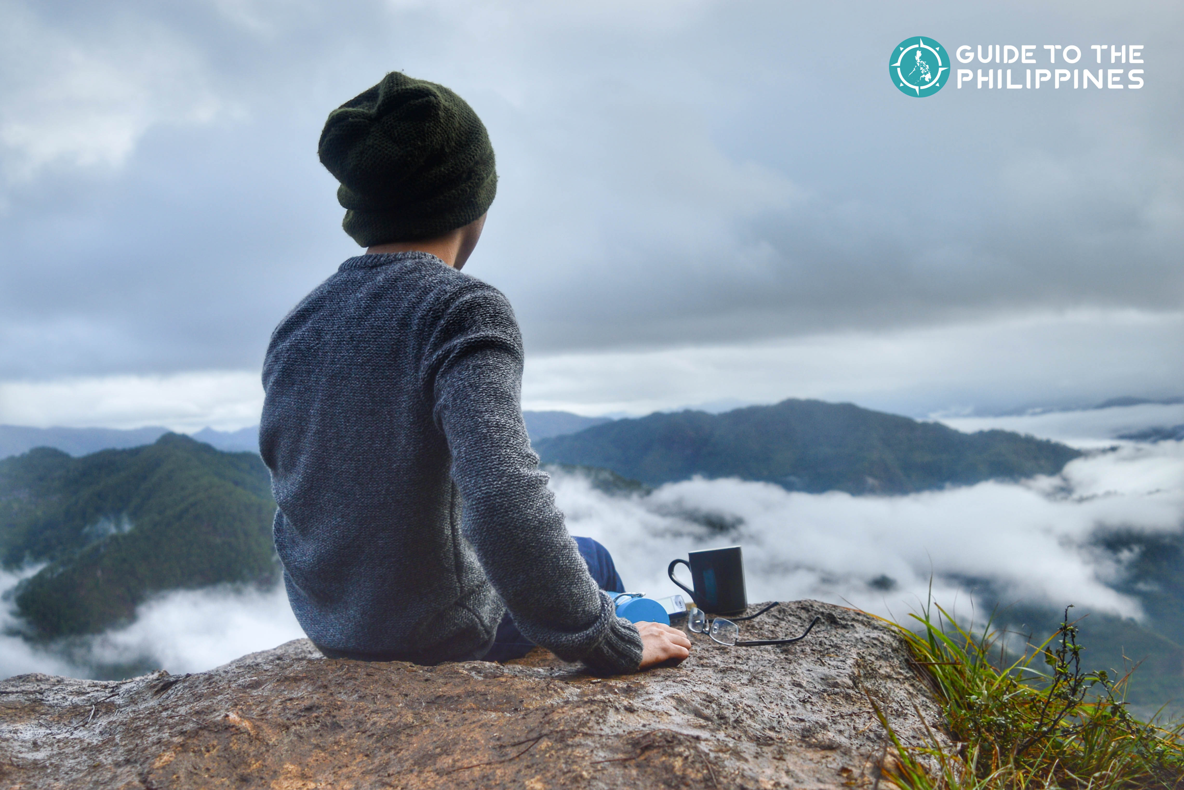 Traveler with a mug of coffee overlooking the mountain peak in Sagada