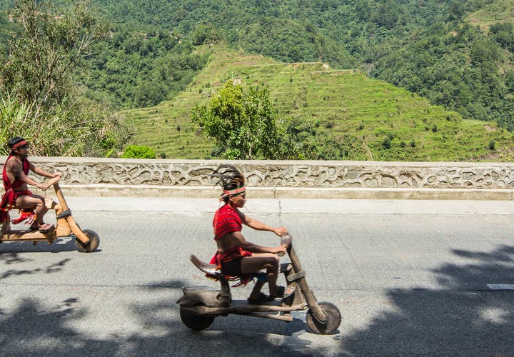 Ifugaos on their wooden scooters in Banaue, Philippines