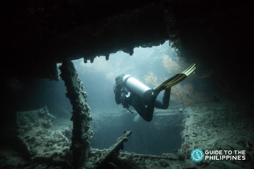 Scuba diver exploring World War II shipwreck in Coron, Palawan Scuba diver exploring World War II shipwreck in Coron, Palawan