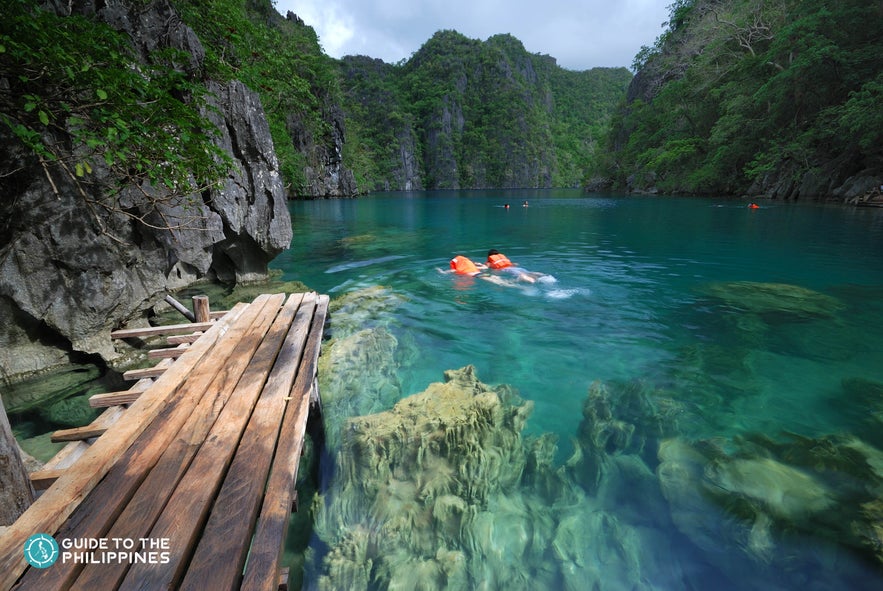 Travelers swimming at Kayangan Lake in Coron, Palawan Travelers swimming at Kayangan Lake in Coron, Palawan