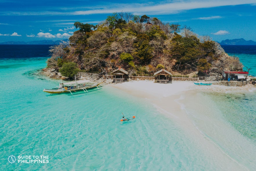 Aerial shot of a traveler kayaking at Bulog Dos Island in Coron, Palawan Aerial shot of a traveler kayaking at Bulog Dos Island in Coron, Palawan