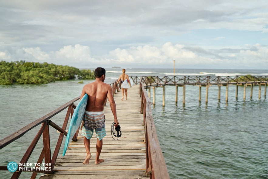 Surfer walking along the Cloud 9 boardwalk in Siargao Island. Surfer walking along the Cloud 9 boardwalk in Siargao Island.