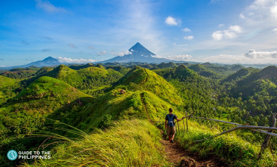 Hiker at Quitinday Hills overlooking Mt. Mayon in Legazpi, Albay, Philippines Hiker at Quitinday Hills overlooking Mt. Mayon in Legazpi, Albay, Philippines
