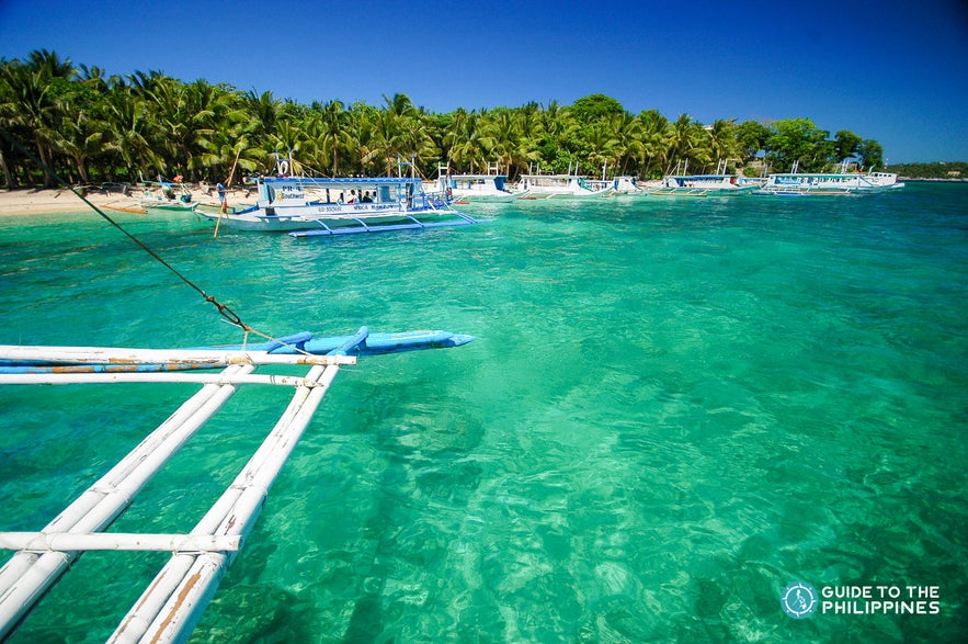 Boat approaching Hilutungan Island's shore Boat approaching Hilutungan Island's shore