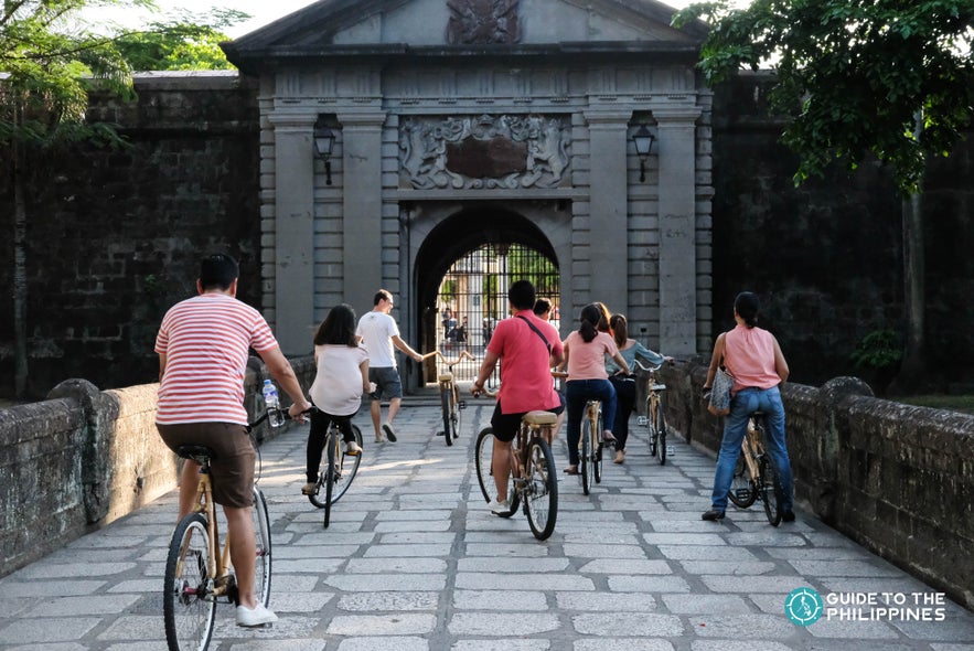 Travelers exploring Intramuros Old Town on eco-friendly bamboo bikes. Travelers exploring Intramuros Old Town on eco-friendly bamboo bikes.