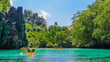 游客在巴拉望科隆的大泻湖划皮划艇
