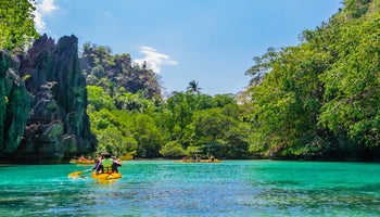 游客在巴拉望科隆的大泻湖划皮划艇
