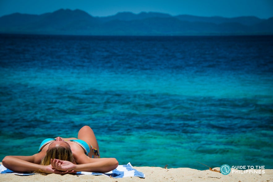 Woman lying down in Palatpat beach in Coron Woman lying down in Palatpat beach in Coron