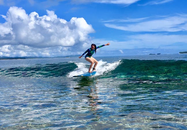 Girl surfing at Siargao surf spot