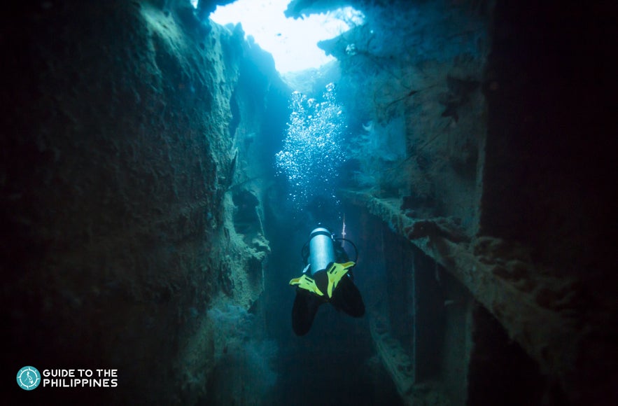 A diver exploring the shipwreck in Kogyo Maru in Coron Palawan A diver exploring the shipwreck in Kogyo Maru in Coron Palawan
