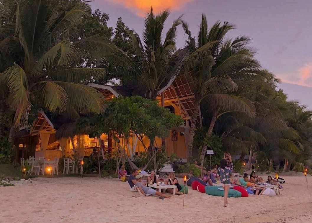 People relaxing on the beach of White Banana Beach Club