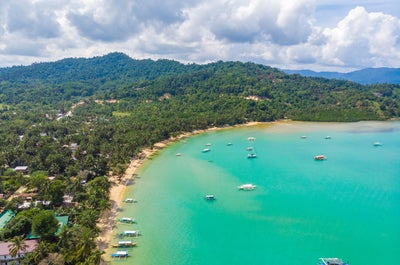 Aerial view of the boats going to the beautiful beach of Port Barton in Palawan