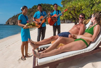 Couple enjoying the sun and some drinks at Club Paradise Resort's white beach