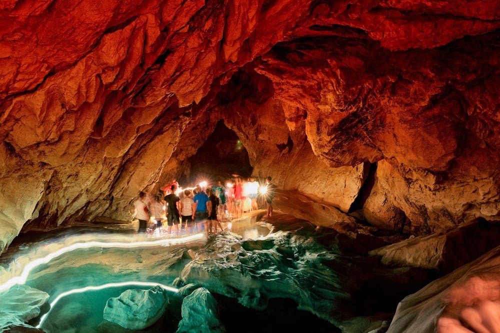 Tourists exploring the rock formations of Sumaguing Cava in Sagada