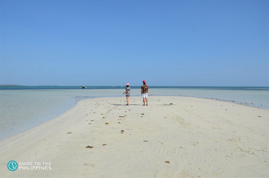 A couple stands on Tondol White Sand Beach in Pangasinan A couple stands on Tondol White Sand Beach in Pangasinan