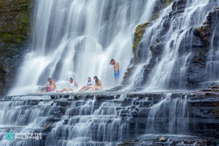 People relaxing under the Merloquet Falls People relaxing under the Merloquet Falls