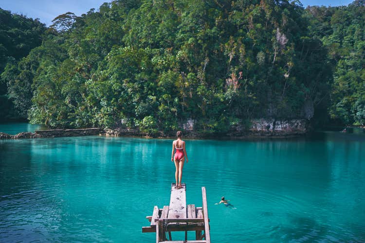 A woman standing on a wooden plank in Sugba Lagoon