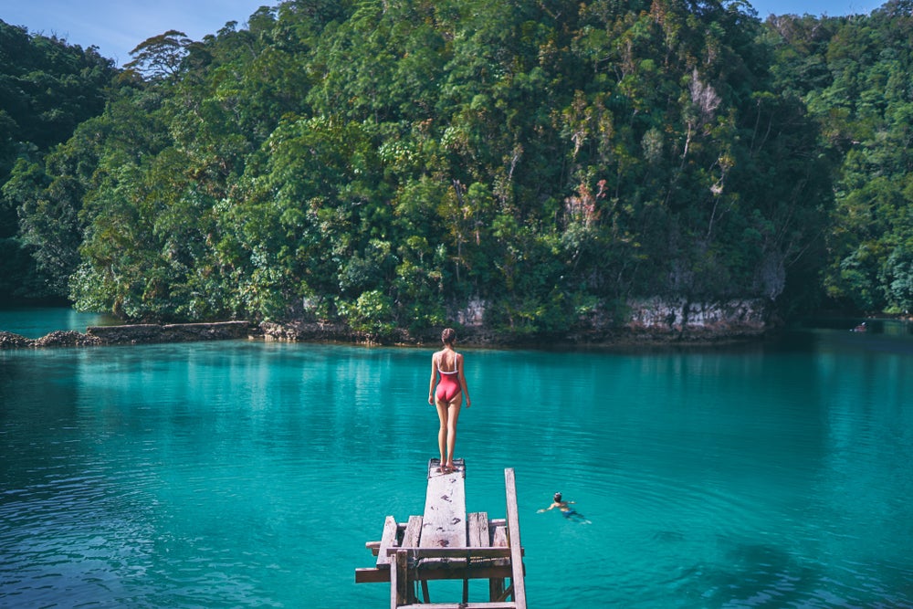 A woman standing on a wooden plank in Sugba Lagoon