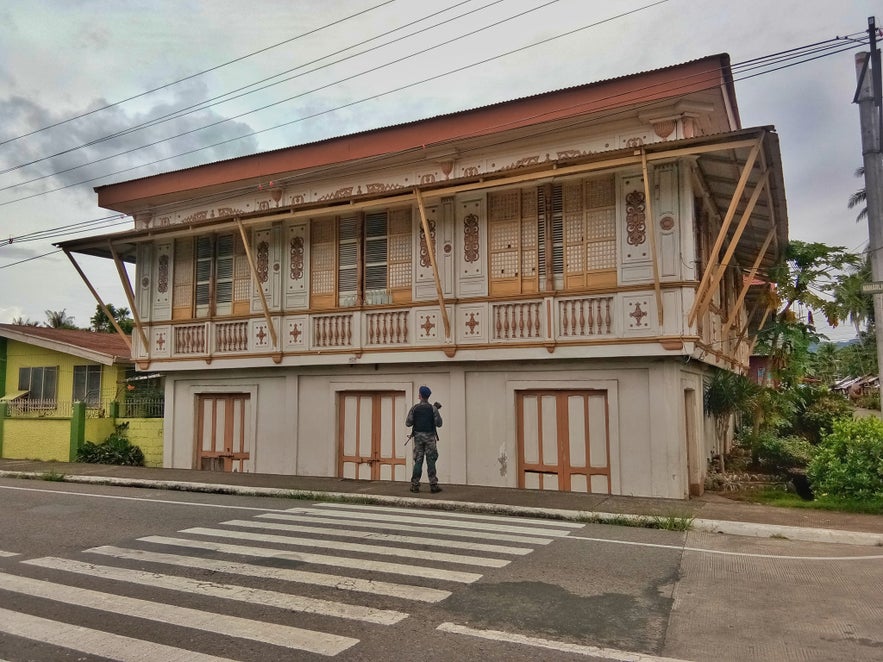 Guard stands infront of a bahay na bato in Juban Guard stands infront of a bahay na bato in Juban