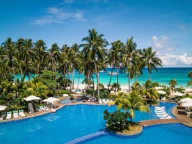 The expansive swimming pool at Movenpick Resort & Spa with a stunning beach view, a perfect spot to lounge during your Boracay Island tour package