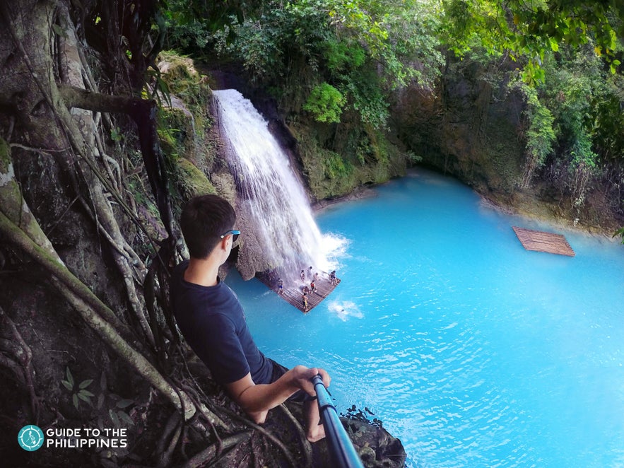 Man getting ready to cliff dive in Kawasan Falls Man getting ready to cliff dive in Kawasan Falls