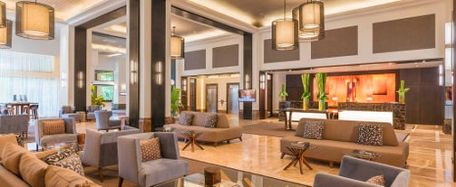 Step into the lobby of Seda Ayala Center Cebu Hotel, part of the luxurious Cebu tour package experience, where a modern, stylish design greets guests with spacious seating and vibrant lighting.