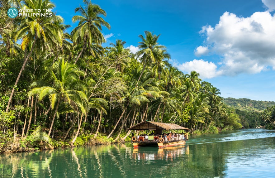 A boat sails along Loboc River A boat sails along Loboc River