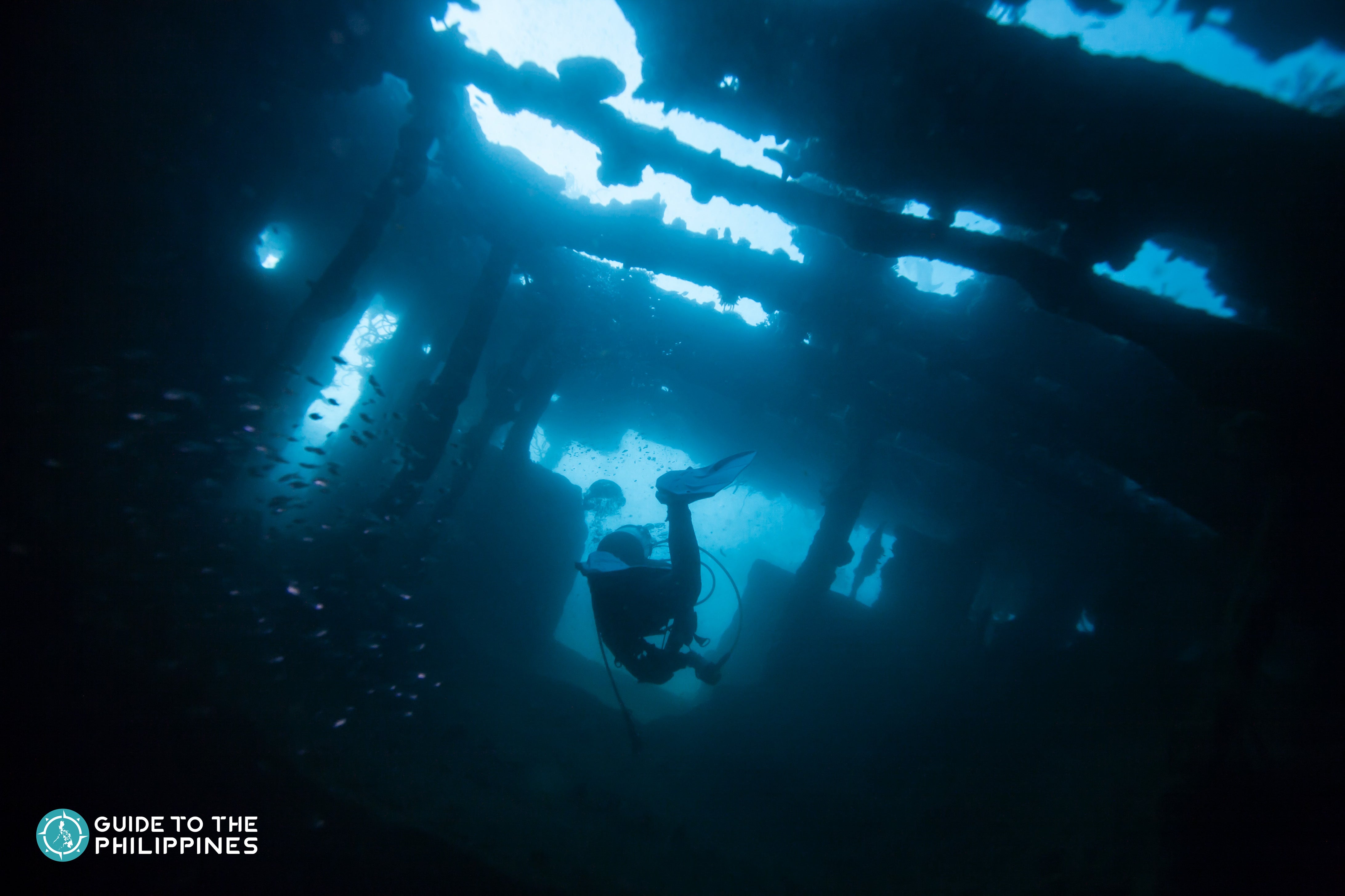 Scuba diver exploring world war II shipwreck in Coron