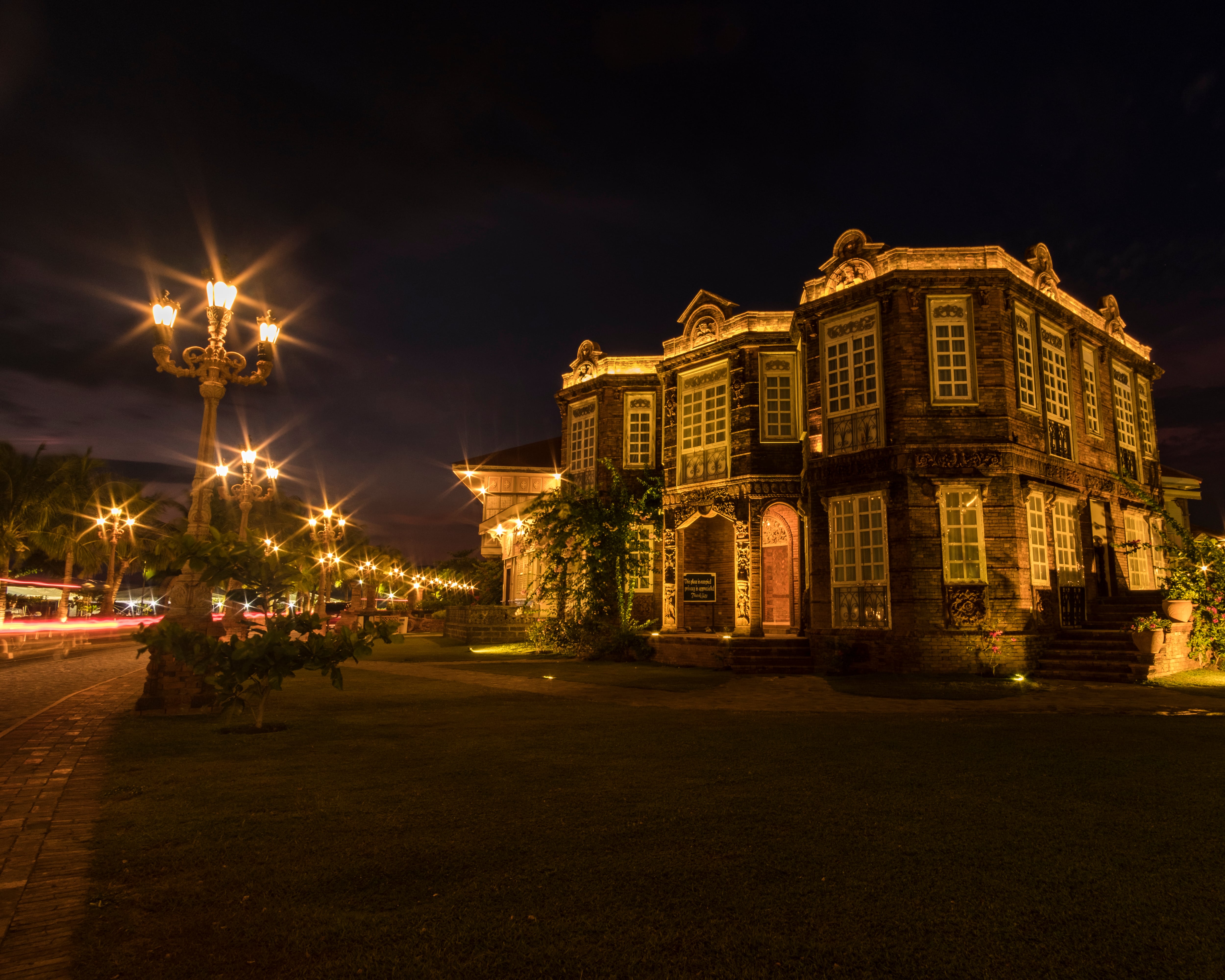 Las Casas Filipinas de Acuzar Heritage Resort beautifully illuminated at night, highlighting its historic architecture beneath the evening sky—a stunning sight that you have the chance to see on this day tour.