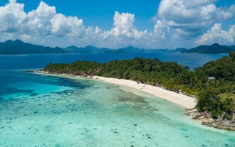 A scenic view of Malcapuya Island, a serene stop on this Palawan Island tour package to El Nido town, Coron town, and Puerto Princesa City.