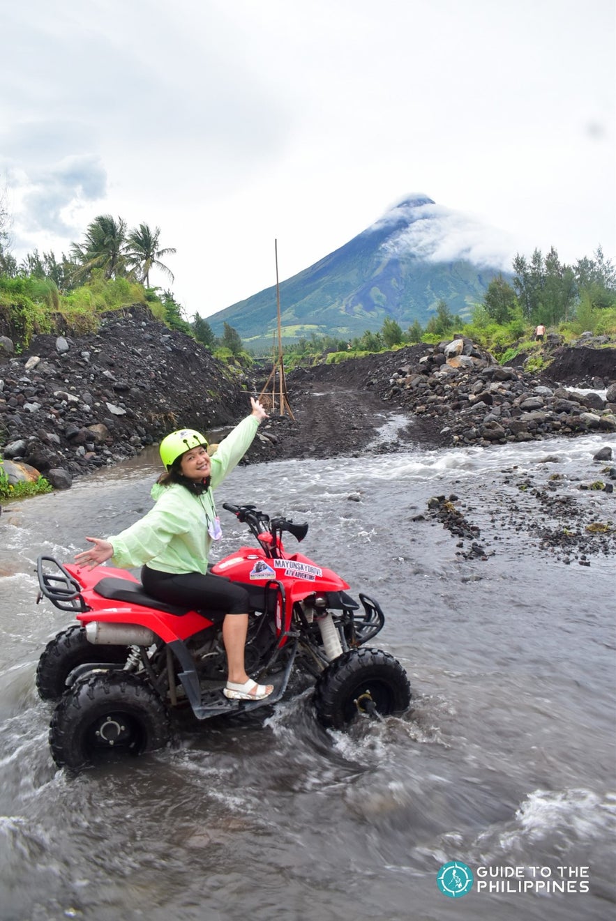 Traveler crossing river by Mayon Volcano Traveler crossing river by Mayon Volcano