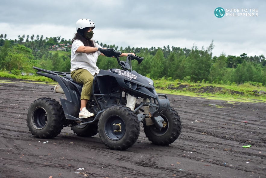 Woman driving an ATV on a dirt path Woman driving an ATV on a dirt path