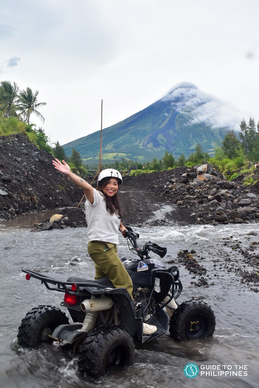 A traveler on a ATV ride with Mayon Volcano in the background.