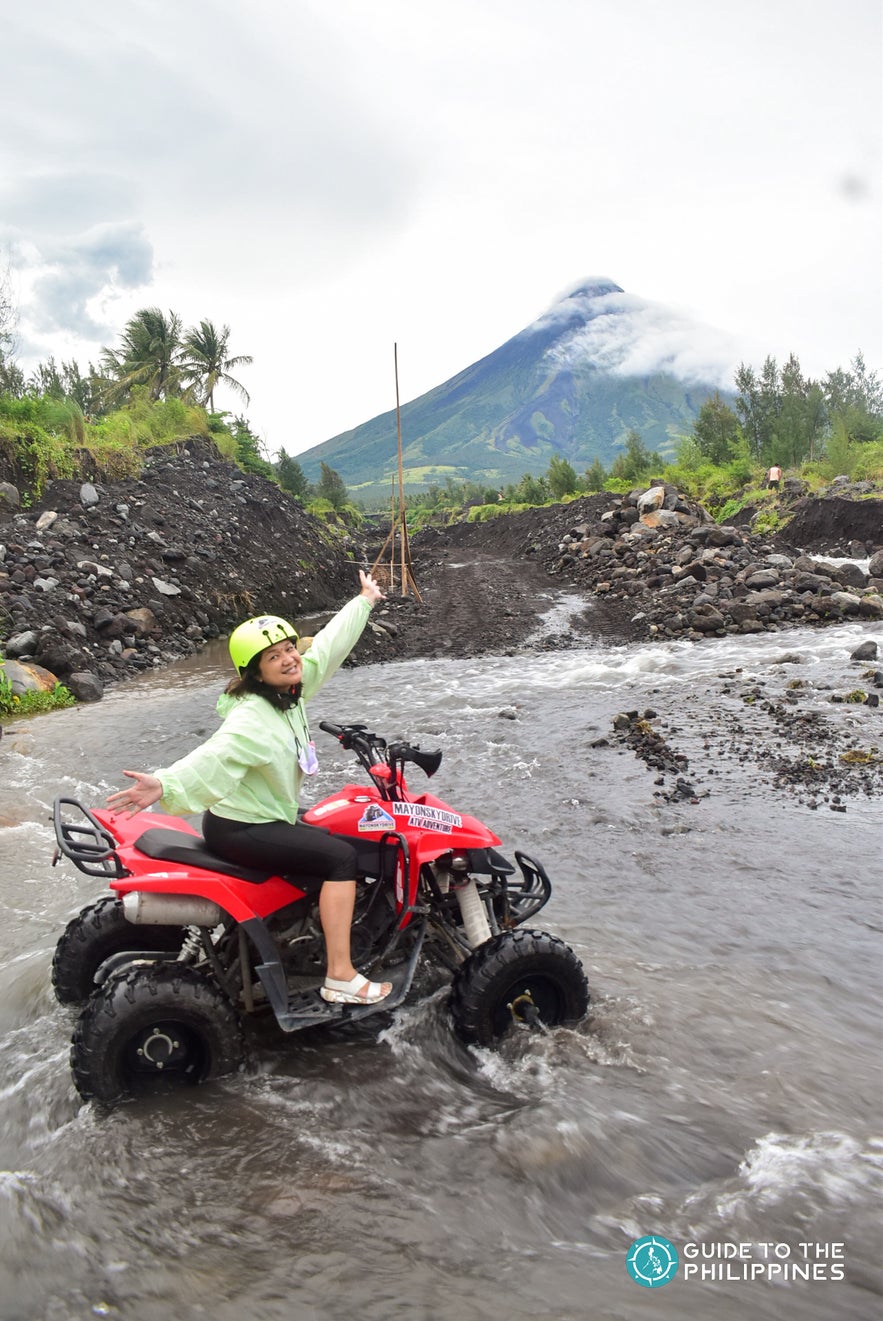 Woman riding an ATV by Mayon Volcano Woman riding an ATV by Mayon Volcano