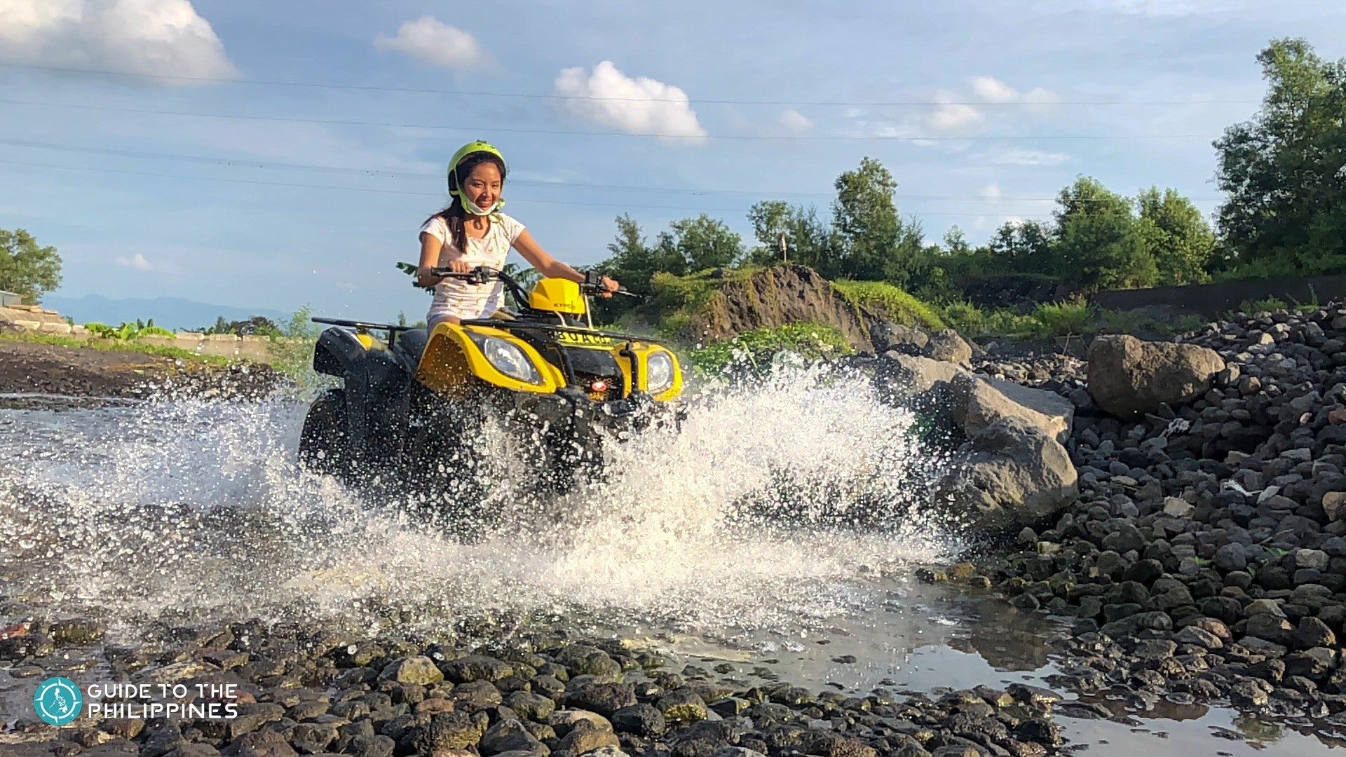 Woman riding an ATV through a river
