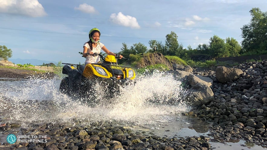 Woman riding an ATV through a river Woman riding an ATV through a river