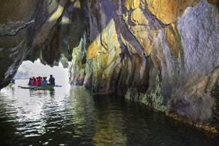Tourists on a Puerto Princesa Underground River tour as they enter the cave system aboard a paddle boat
