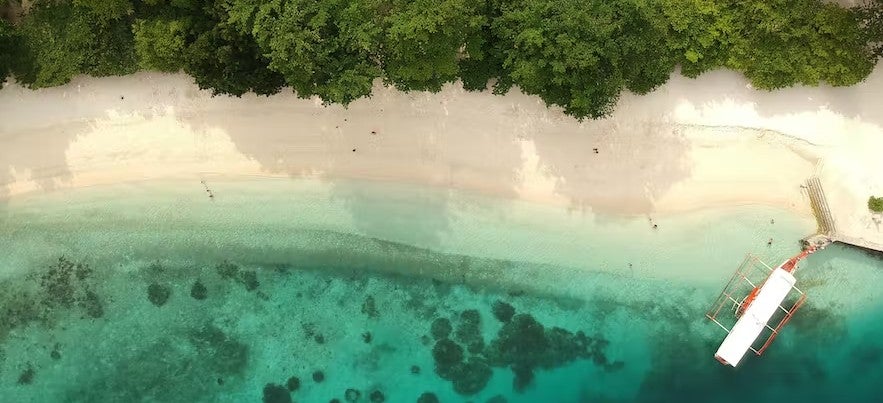Aerial view of a stunning white sand beach during this Samal Island hopping tour from Davao City.