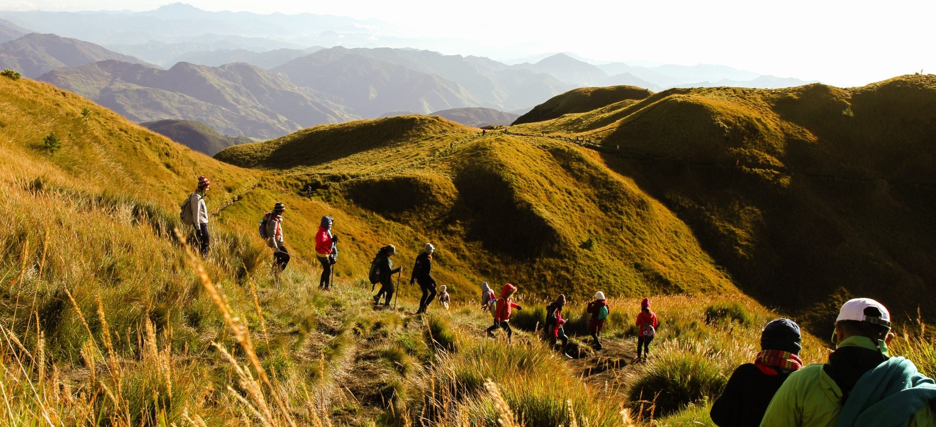 Hikers embarking on a hiking tour to Mt. Pulag, surrounded by mountain landscapes and scenic views.