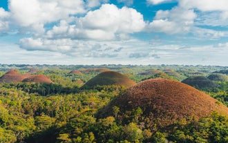 Your land tour in Bohol Island brings you to the iconic Chocolate Hills, where you can admire the breathtaking landscape from the observation deck.
