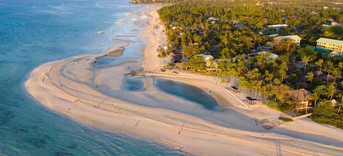 A stunning aerial view of Kota Beach showcasing its curved stretch of sand, a must-visit spot on your tour to Bantayan Island