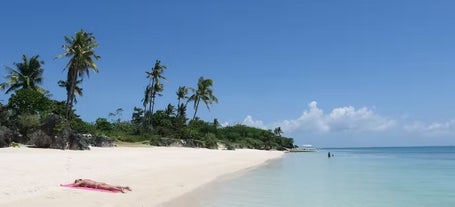 A tourist relaxing on a white sand beach during their Bantayan Island tour