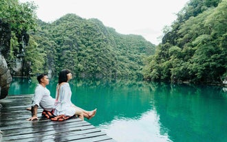 Visitors admiring the turquoise waters and lush greenery of Kayangan Lake on this Coron town highlights tour with private speedboat