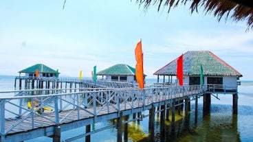 The picturesque boardwalk over turquoise waters enhances the breathtaking experience of this Stilts Calatagan Beach Resort day tour.