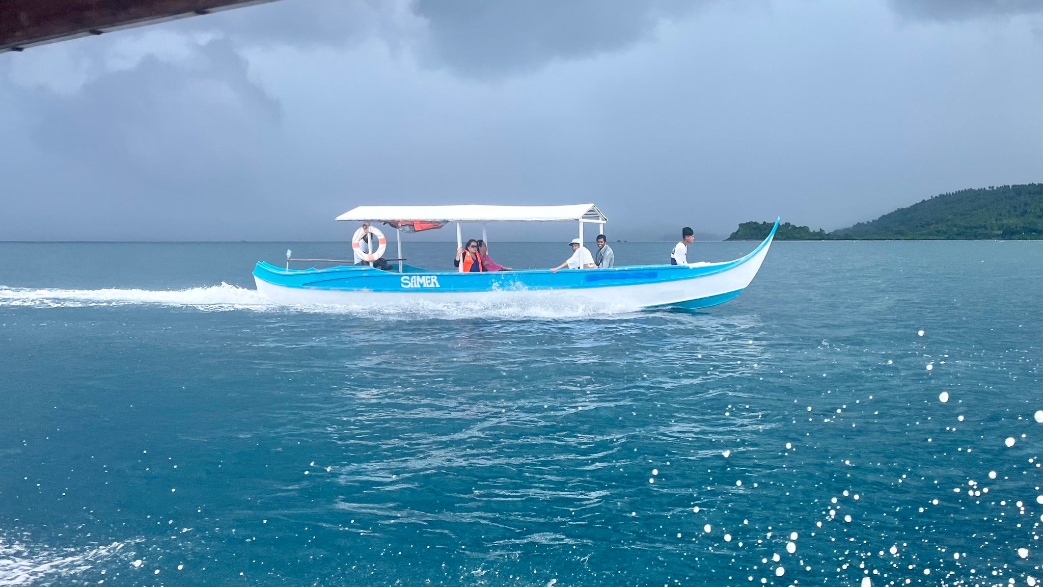 A long, blue-and-white motorized boat carries tourists across the clear blue sea on this private Once Islas Islands tour in Zamboanga City.