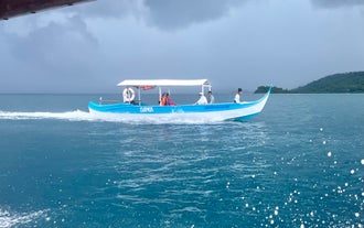 A long, blue-and-white motorized boat carries tourists across the clear blue sea on this private Once Islas Islands tour in Zamboanga City.