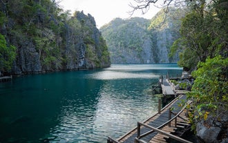 The dramatic rock formations surrounding the clear waters of Kayangan Lake, a highlight of this Coron Island hopping tour on a party boat